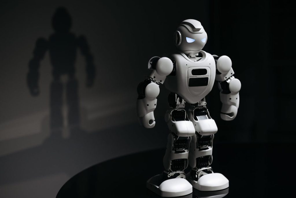 White robot toy casting a shadow in a dark studio setting, highlighting artificial intelligence.